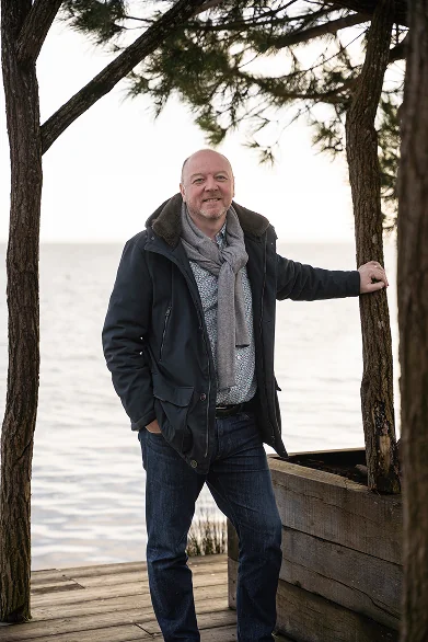 Photo de geoffrey au bord de l ocean pose contre un pin