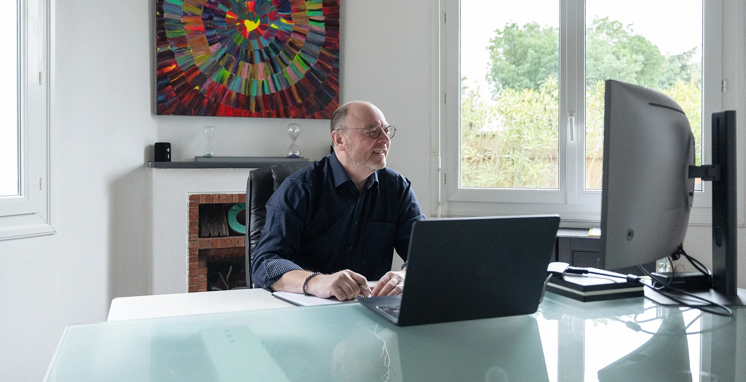 Photo de geoffrey dans son bureau en visioconference avec un client